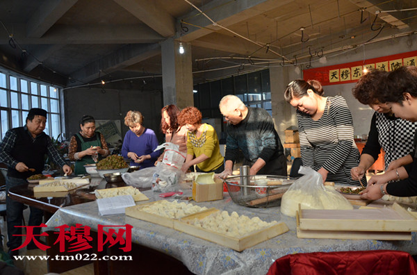    志愿者正忙着包饺子。