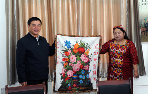 11月8日，社区居民左然木·扎热在给中央宣讲团成员刘佳义赠送绣品。
