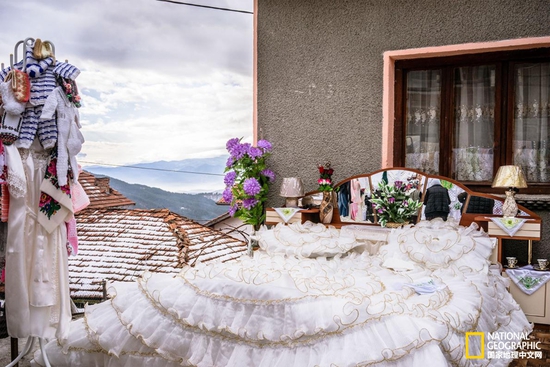 出嫁 化过妆的Salve Kiselova即将步出娘家大门，她闭着双眼，面孔挂满了传统饰品。摄影：GUY MARTIN, NATIONAL GEOGRAPHIC