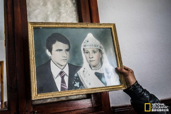 留影 Tahrir Serdarev向我们展示他姑姑与姑父的结婚照。摄影：GUY MARTIN, NATIONAL GEOGRAPHIC
